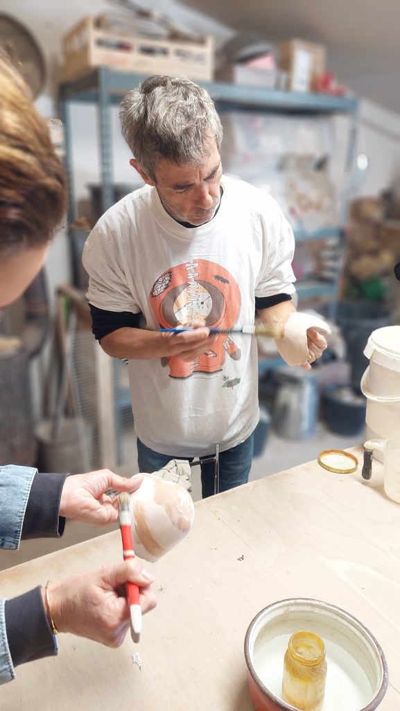 Stage de céramique. Stage de poterie raku. Cirage des pièces avant l'émaillage et la cuisson raku